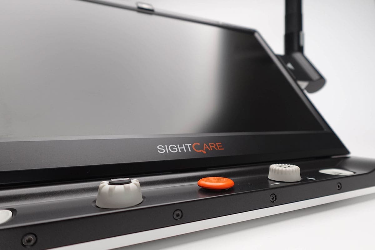 A close-up of a device with a screen labeled "SIGHTCARE," featuring buttons and knobs on the front.